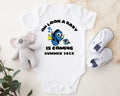 Baby onesie with Dory and Nemo design, baby shoes, and plush toy on a light background
