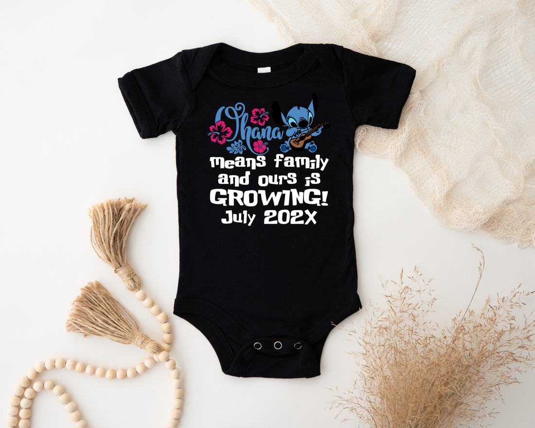 White baby onesie with cartoon character and text on a textured surface